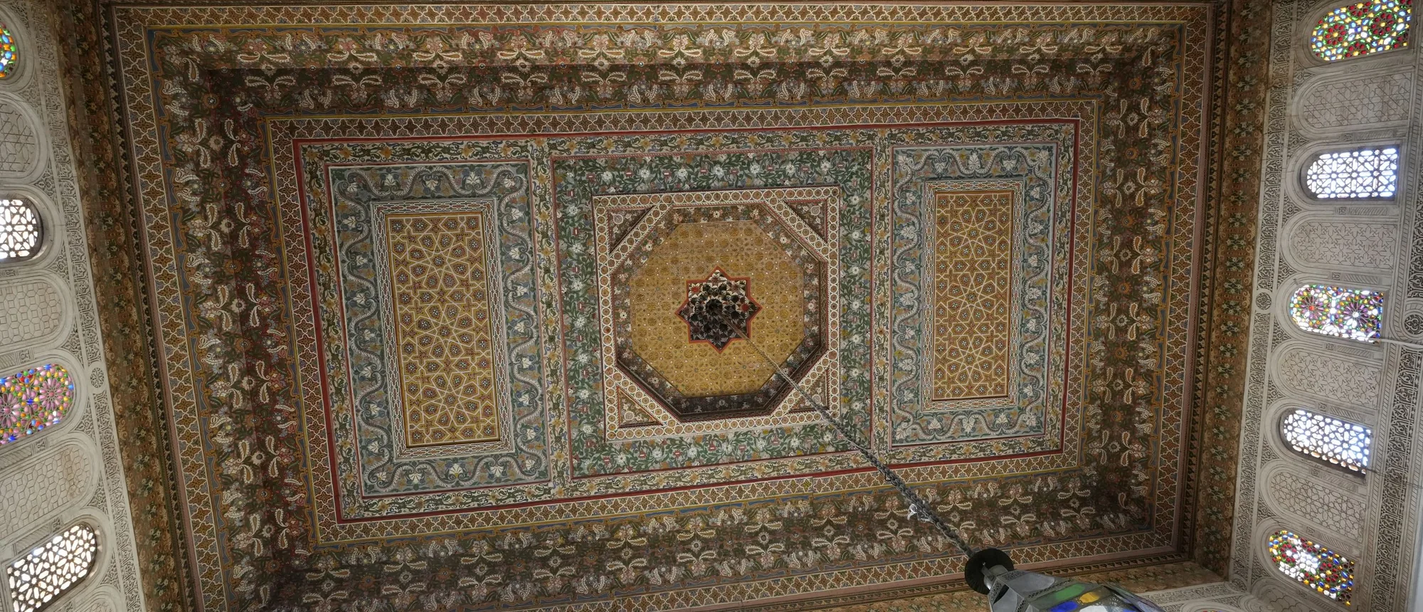 A painted and carved wooden ceiling in Marrakesh, patterned around a central octagonal medallion
